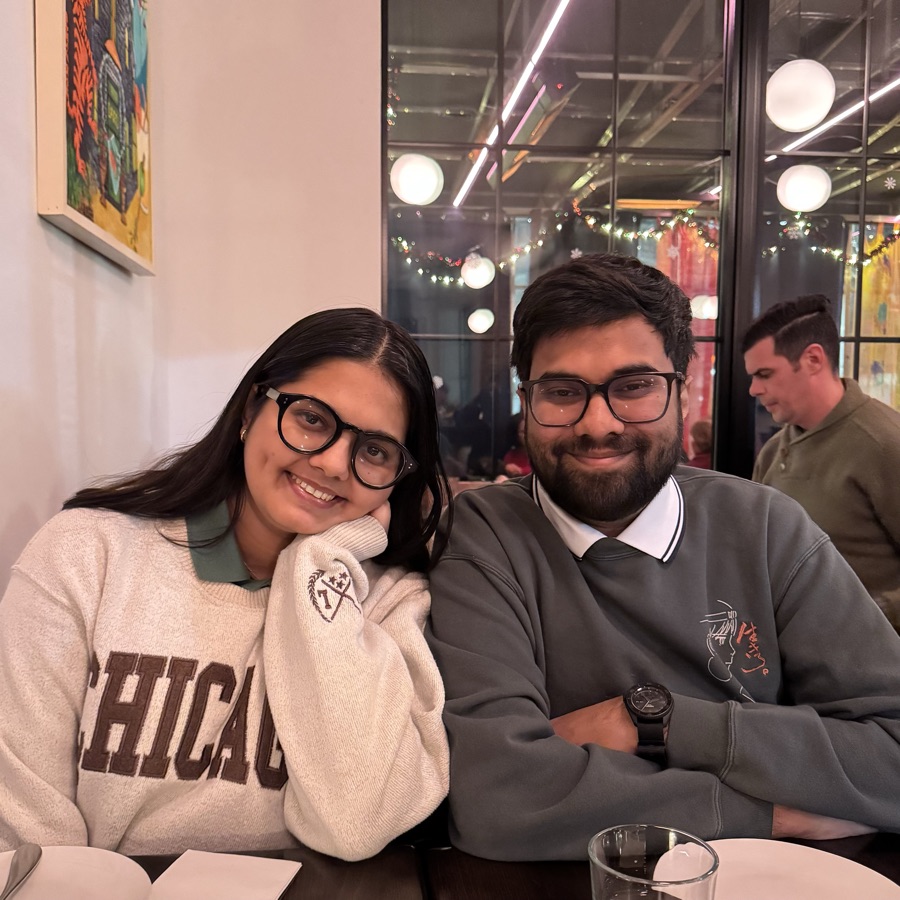 Manasi and Arush smiling side by side at a restaurant table